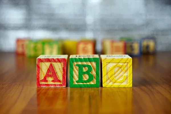 Arreglo de letras ABC utilizando bloques de alfabeto de madera coloreados.Enfoque selectivo, profundidad de campo poco profunda . —  Fotos de Stock