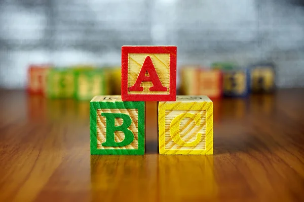 Arreglo de letras ABC utilizando bloques de alfabeto de madera coloreados.Enfoque selectivo, profundidad de campo poco profunda . —  Fotos de Stock