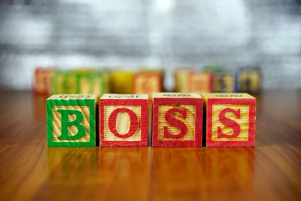 Word of BOSS spelled with colorful wooden alphabet blocks.Selective focus,shallow depth of field. — Stock Photo, Image