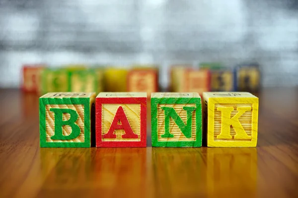 银行一词的拼写与多彩木制字母块。选择性的焦点，浅景深. — 图库照片