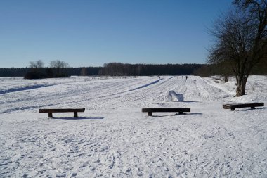 Kar tarlasının kenarındaki banklar