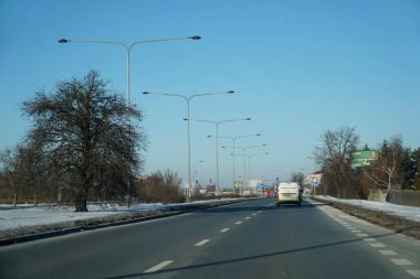 Varşova, Polonya - 4 Şubat 2026: Güneşli bir kış gününde Przyczolkowa Caddesi boyunca araba sürüyor