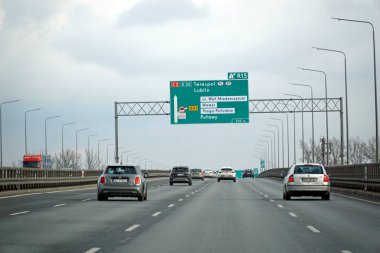 Varşova, Polonya - 2 Şubat 2025 Bulutlu bir kış gününde otoyolda giden arabalar