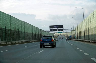 Varşova, Polonya - 2 Şubat 2025 Varşova baypasındaki gürültü azaltma duvarları arasında giden arabalar