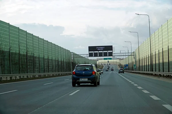 Varşova, Polonya - 2 Şubat 2025 Varşova baypasındaki gürültü azaltma duvarları arasında giden arabalar