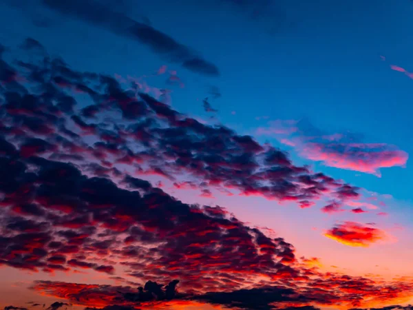 Red sunset on a cloudy blue sky with clouds. Pink evening dawn. Morning red pink sunshine dawn. Clouds in the blue sky. Pink morning dawn. Heavenly landscape. Space. Stratosphere.