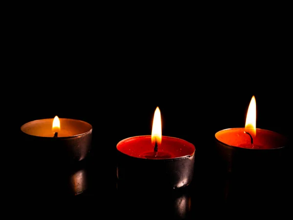 Flame of fire of burning wax candles on a black background. Wax candles. Flame of burning fire. Day of Remembrance. A minute of silence. Memorial Day. Place for your text. Background image.
