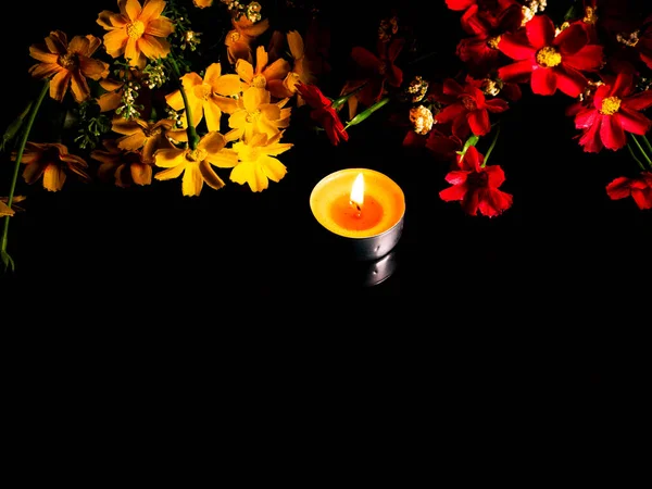 Flame of fire of burning wax candles on a background of flowers. — Stock Photo, Image