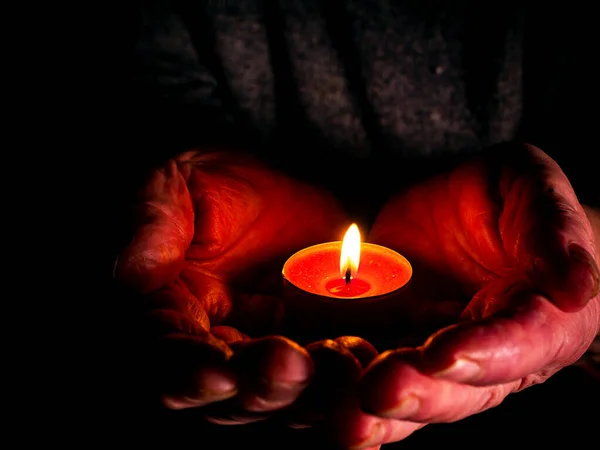 Flacără de foc de lumânări de ceară arzătoare în palmele mâinilor . — Fotografie, imagine de stoc