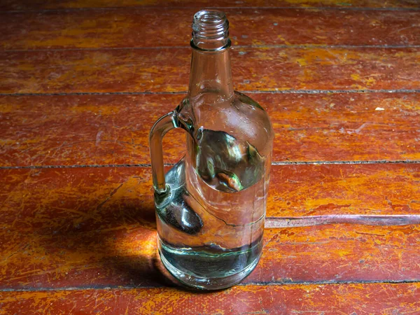 Ahşap arka planda sapı olan votka için cam şişe. Cam bir şişenin boynu. - Alkol. Alkol için cam eşyalar. Kötü alışkanlıklar. Alkolizm. Arkaplan resmi. Saplı bir konteynır.