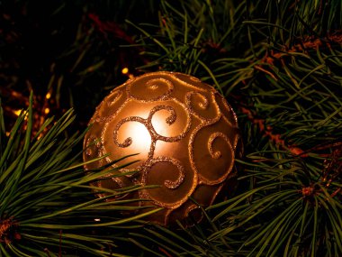 Noel ağacında altın renginde camdan bir top. Mutlu noeller. Yeni yıl. Yeni yıl partisi. Dekoratif oyuncak. Çam ağacı. Noel Baba hediyeleri. Kış tatili Şenlik partisi. Arkaplan resmi.