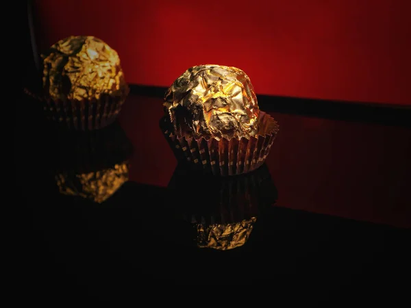 Caramelos Redondos Lámina Dorada Sobre Fondo Negro Rojo Chocolates Envueltos — Foto de Stock