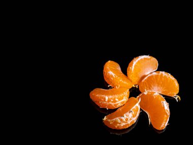 Siyah arka planda soyulmuş mandalina dilimleri. Turuncu mandalina. Portakal Suyu, Meyve Suyu. Bahçe turunçgilleri hasat ediliyor. Tarım. Vejetaryen yemeği. Yemek fotoğrafı. Arkaplan resmi.