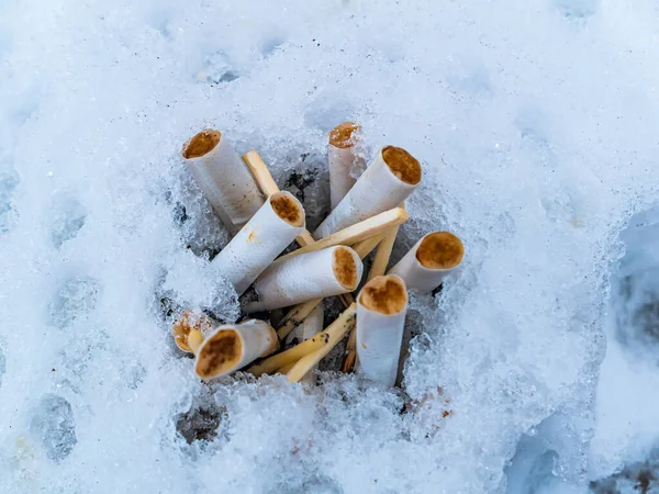 Posacenere da neve con mozziconi e fiammiferi. — Foto Stock
