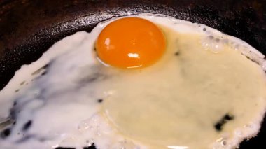 Tavuk yumurtasından yağda yumurta tavada kızartılır. Tavada yumurta kızartma. Yumurta sarısı. Yemek pişirmek. Kahvaltı hazırlamak için. Ev mutfağı. Yemek menüsü. Mutfak tabağı. 4K video.