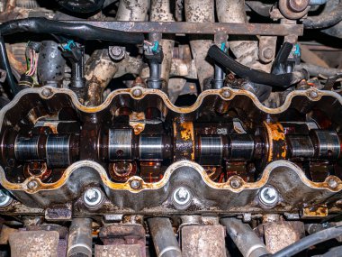 Bir yolcu aracının silindir başının tamiri. Motor tamiri. Araba servisi. Araçların bakımı. Tamirci. Otomotiv atölyesi. Çilingir uzmanı. Silindir bloğu.