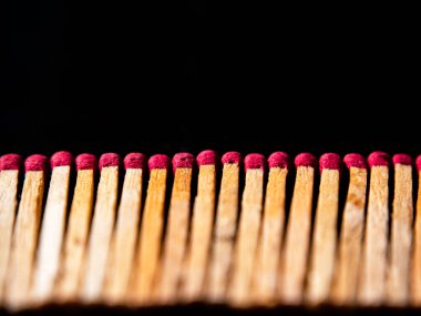 Siyah arka planda kırmızı sülfür başlarıyla ahşap kibritler. Ateşleme kibriti. Kibrit kutusu. Kırmızı sülfür. Siyah arka plan. Ahşap. Arkaplan resmi. Metnin için yer.