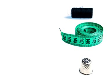 Beyaz arka planda terzi santimetresi ve dikiş aksesuarları. Terzi kadın santimetresi. Metre cetvel. İnç ve santimetre. Kesme ve dikme. Olezhda tamir ve dikiş. İp makarası.