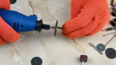 Dremel zümrüt bir diskle metali kesiyor. Mini matkap. Demir kesme diski. Dremel iş aleti. Elektrik teçhizatı. İşleme ekipmanları. Öğütme makinesi. Metal işleme.