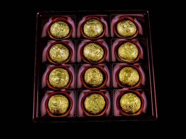 Uma Caixa Chocolates Papel Alumínio Dourado Sobre Fundo Preto Doces — Fotografia de Stock