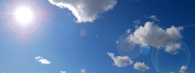 Güneşin panoramik fotoğrafı beyaz bulutlu mavi gökyüzüne karşı. Güneş parlıyor. Mavi gökyüzü. Beyaz bulutlar. Boşluk. Atmosfer. Hava açık. Doğal arka plan. Arkaplan resmi.