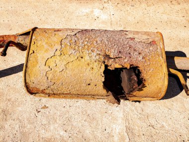 Yanmış bir deliği olan paslı bir araba egzozu. Arabanın egzoz sistemi. Otomatik susturucu. Araç. Yedek araç parçası. Müşteri Hizmetleri. Tamir ve servis. Metal detay. Tamirci geldi. Efendim!.