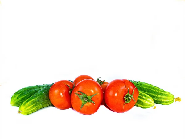 Legumes tomates vermelhos e pepinos em um fundo branco. — Fotografia de Stock