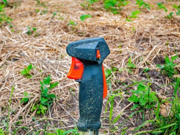 芝刈り機用の赤いボタン付きブラックハンドル 遠隔操作 トリマーハンドル 芝刈り機で芝生を刈る 庭の設備 ガーデンツール 産業機器 — ストック写真