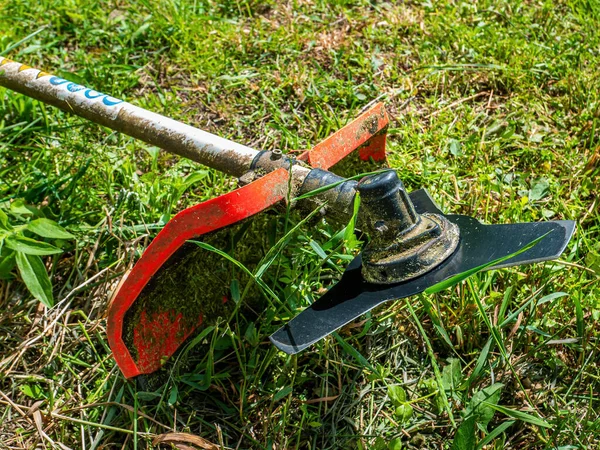 Çim biçme makinesi çim biçmek için disk kesiyor. Bıçak ağzı. Kesici diski kesiyor. Çimleri bir çim biçme makinesiyle biçin. Güvenlik önlemleri. Bahçe malzemeleri. Bahçe aletleri. Endüstriyel.