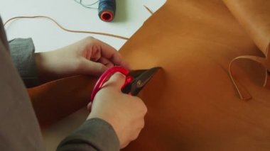 Makas bir deri parçasına kesik atar. Hakiki deriden yapılmış özel ürünler üretmek için kullanılan eski moda bir yöntem..