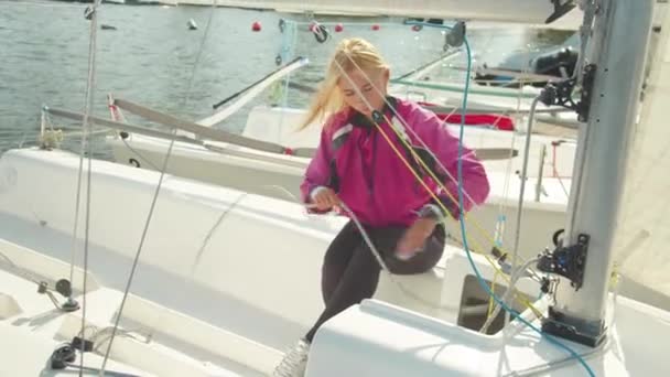 Due atleti coraggiosi si stanno preparando per una regata a vela di più giorni su un piccolo yacht. Controllare il sartiame e allungare le corde e cavi. — Video Stock