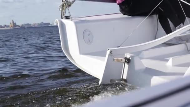 Een team van atleten ontvouwt een zeiljacht tijdens een regatta op de rivier, kunt u de bezienswaardigheden van de stad te zien. Langzame beweging — Stockvideo