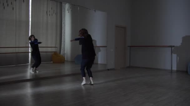 Apasionada por la danza moderna, una bailarina realiza nuevos movimientos con un espejo para su danza contemporánea en una escuela de baile. — Vídeo de stock