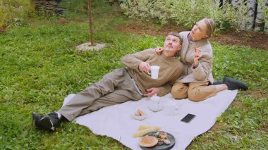 Bir karı koca, kendi köy evlerinin yakınlarındaki aile bahçesinde piknik yapmışlar. Çay içerler, abur cubur yerler..
