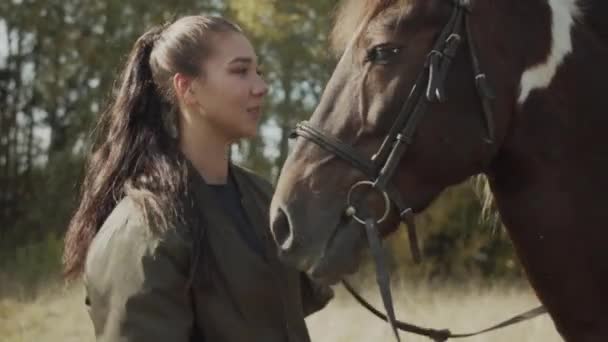 Een charmante jonge vrouw uit haar dankbaarheid aan een paard voor een aangename rit op het door te knuffelen, kussen en strelen. — Stockvideo