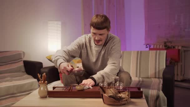 Muž utírá kapky rozlitého čínského čaje ze stolu po skončení obřadu domácího čaje. — Stock video