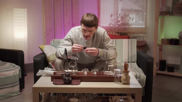 Der Teemeister ist leidenschaftlich daran interessiert, zu Hause eine Teezeremonie abzuhalten. Legt Stücke Puerh-Tee in eine Glasteekanne mit Ei, um authentischen chinesischen Tee zu brauen. — Stockvideo