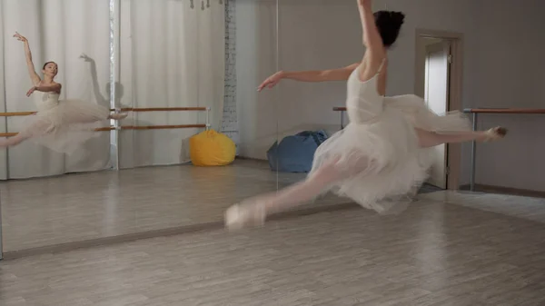 Schuss in Zeitlupe. Charmante Ballerina macht einen schönen Sprung und setzt ihren Tanz mit Schritten und Pirouetten fort — Stockfoto