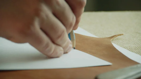 クローズアップ鉛筆は、パターンを概説し、排他的な製品を作成するために切断のための本革の一部をマークします。. — ストック写真
