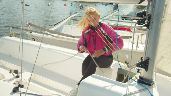 Two brave athletes are preparing for a multi-day sailing regatta on a small yacht. Check the rigging and stretch the ropes and cables. — Stock Photo, Image