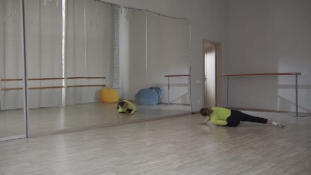 Skocz z split pięknej dziewczyny współczesnej tancerki. Przestronne studio z dużym lustrem w szkole tańca. Trening z rozgrzewką. — Wideo stockowe
