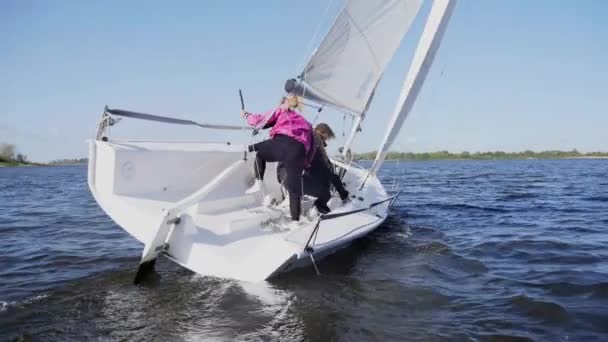 Három sportolót helyeznek át a vitorlás hajó másik oldalára, miközben a regattánál vezetik a hajót. Lassú mozgás. — Stock videók