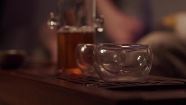Mestre de chá japonês mergulha na atmosfera de uma cerimônia de chá real, derrama chá puer forte em uma xícara de um frasco. — Vídeo de Stock