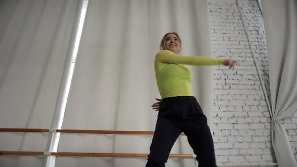 전문 발레리나는 현대 안무가 벽과 커튼 근처의 댄스홀에서 발레 요소를 가지고 춤을 추며 바닥부터 앞까지 촬영 한다 — 스톡 사진