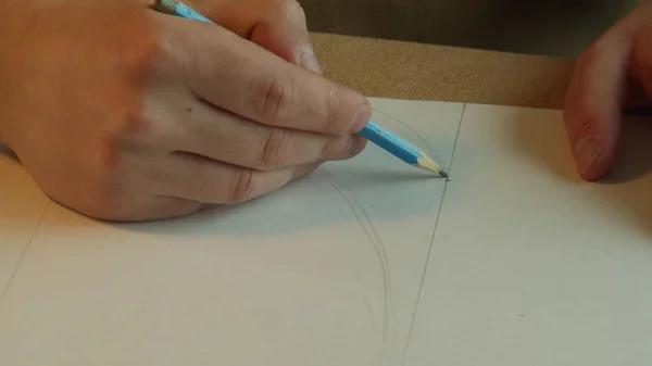 Dessiner des motifs au crayon sur papier blanc gros plan. Concept des travaux en cours. — Photo