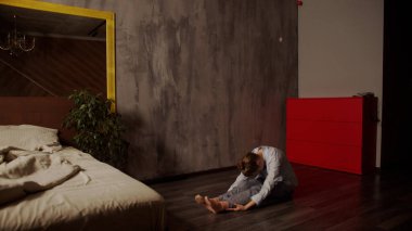 Genç yetişkin bir kız yatak odasında Asyalı bir savaşçı gibi duruyor. Sağlıklı yaşam tarzı, evde eğitim.. 