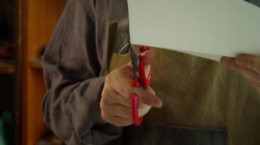 Yetenekli bir terzi, bir kağıt parçasından deri malzemeler yapmak için bir model oluşturur..