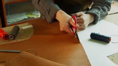 Gerçek deriden yapılmış tasarımcı ayakkabıları yaratmaya hazırlanan Tanner 'ların genel görünümü. Deriyi makasla keser..