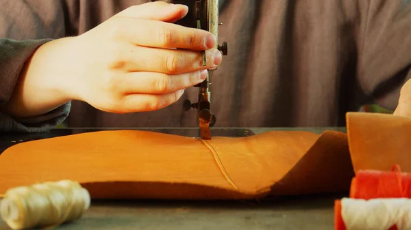 A close-up tailor makes a neat high-quality seam on the element of a leather product using a sewing machine. Slow motion. — Stock Photo, Image