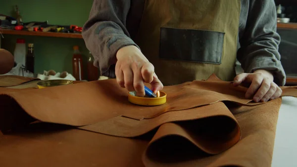 A leather craftsman melts a special wax with a lighter to care for natural leather. — Stock Photo, Image